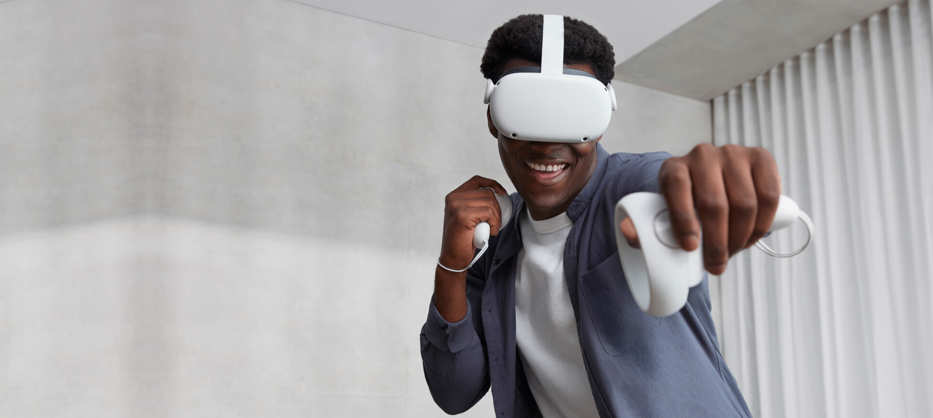 Person wearing a VR headset and holding controllers indoors.
